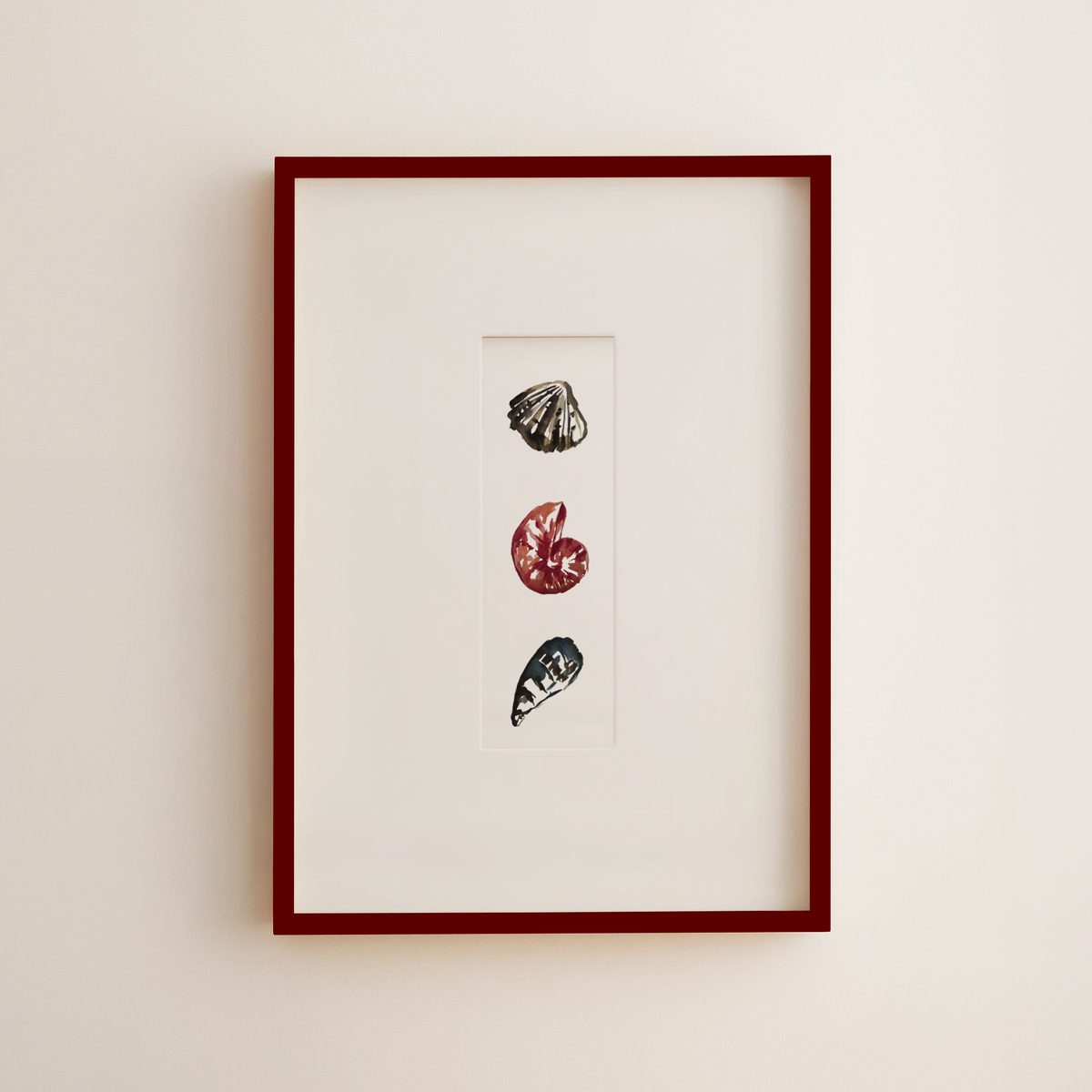 Framed vertical art print featuring three small seashell illustrations in black, red, and gray on a white mat, set in a dark red frame against a light beige wall.